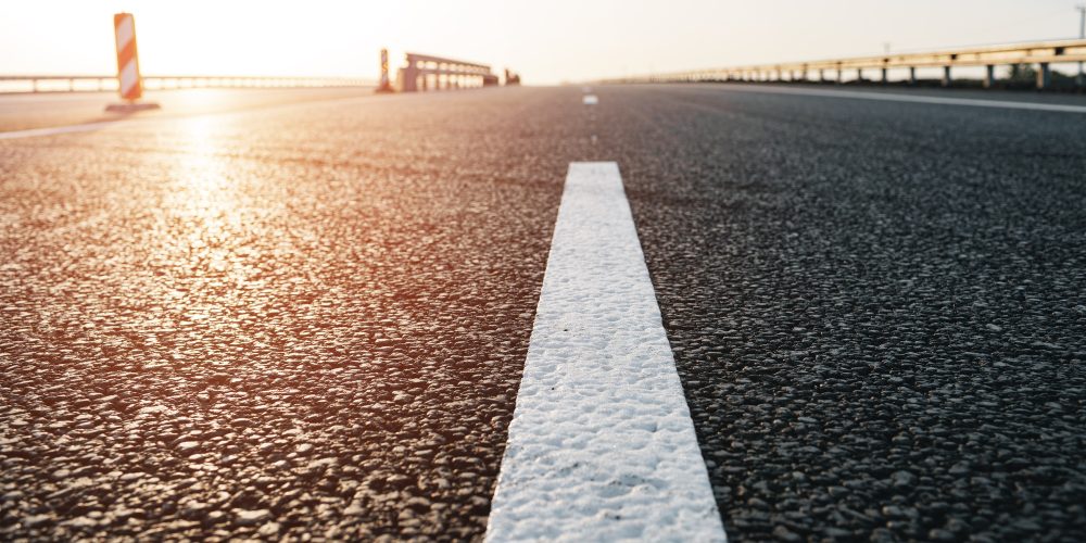 white-marking-line-on-asphalt-road-on-highway-2KX3ZDG